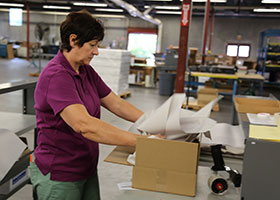 Employee packing shipping boxes